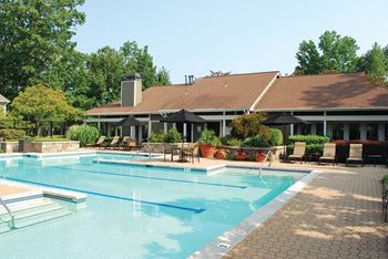 a large swimming pool in front of a hotel with a building